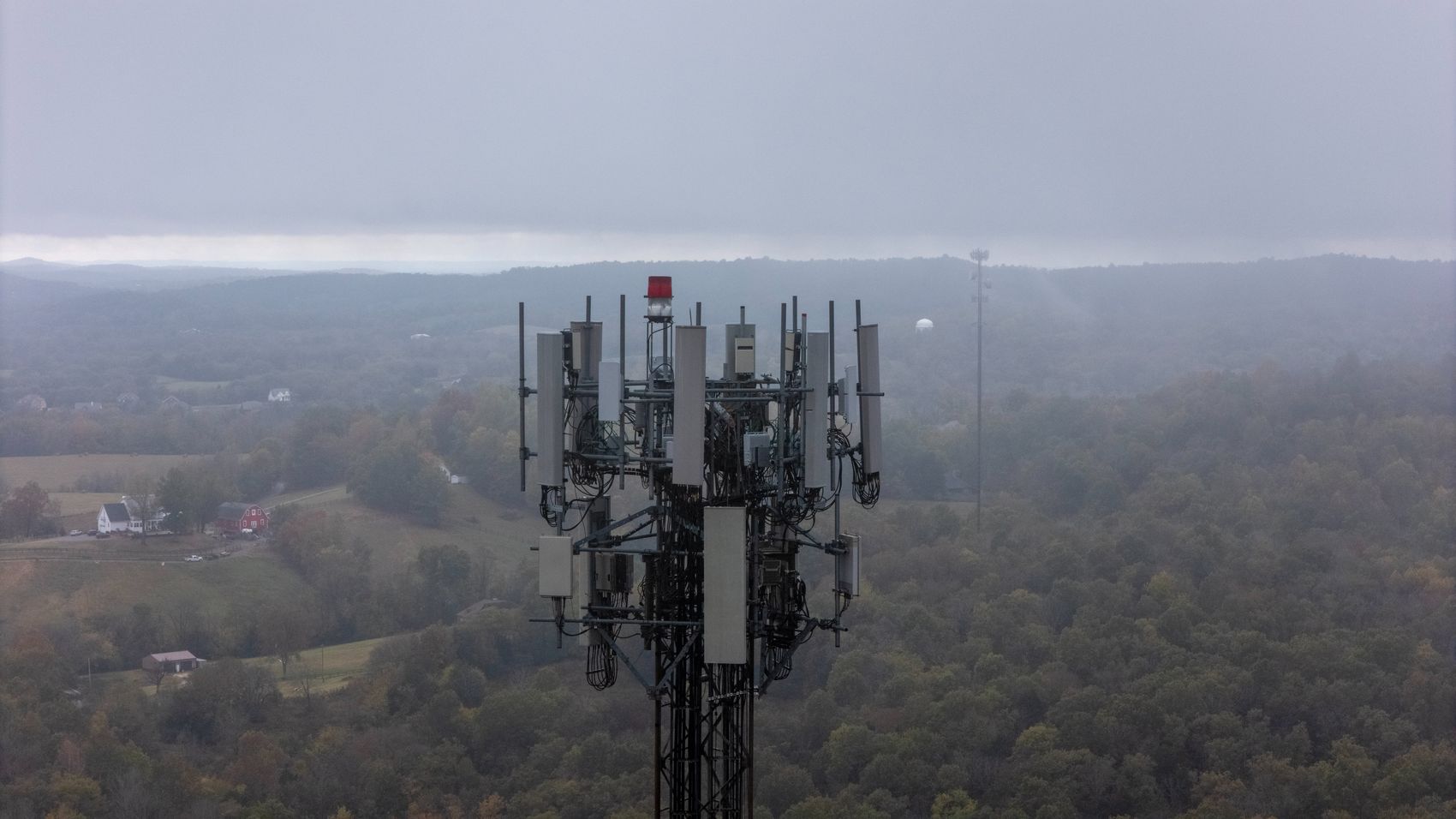 Aerial view of a communications cell tower above a rural Tennessee landscape in morning fog